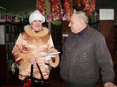 На снимке автор знакомит читательницу библиотеки Шепелеву Веру Викторовну с новой книгой